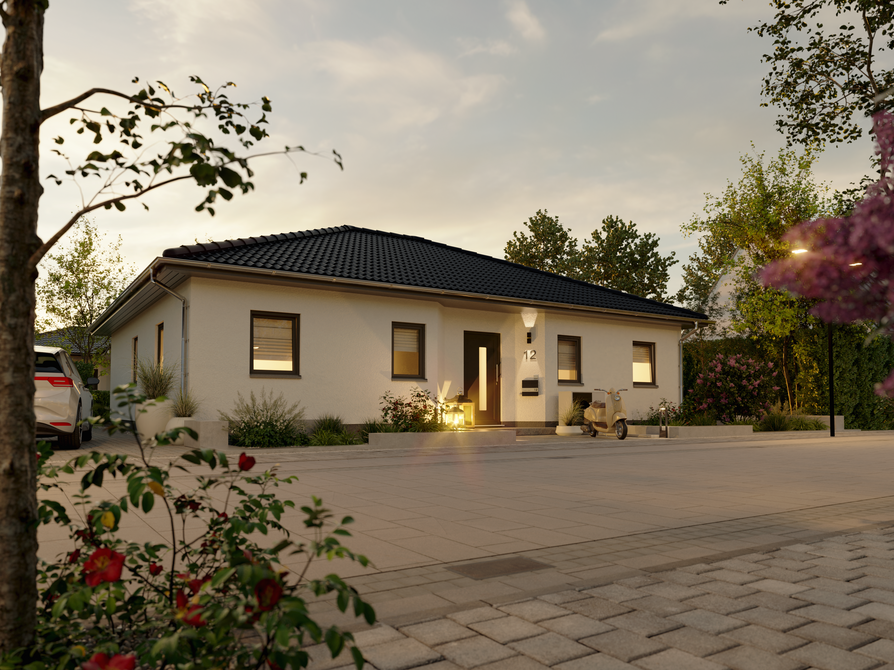 Straßenansicht des Winkelbungalow 108 bei untergehender Sonne mit beleuchtetem Eingangsbereich, Vorgarten und Hausnummer 12.